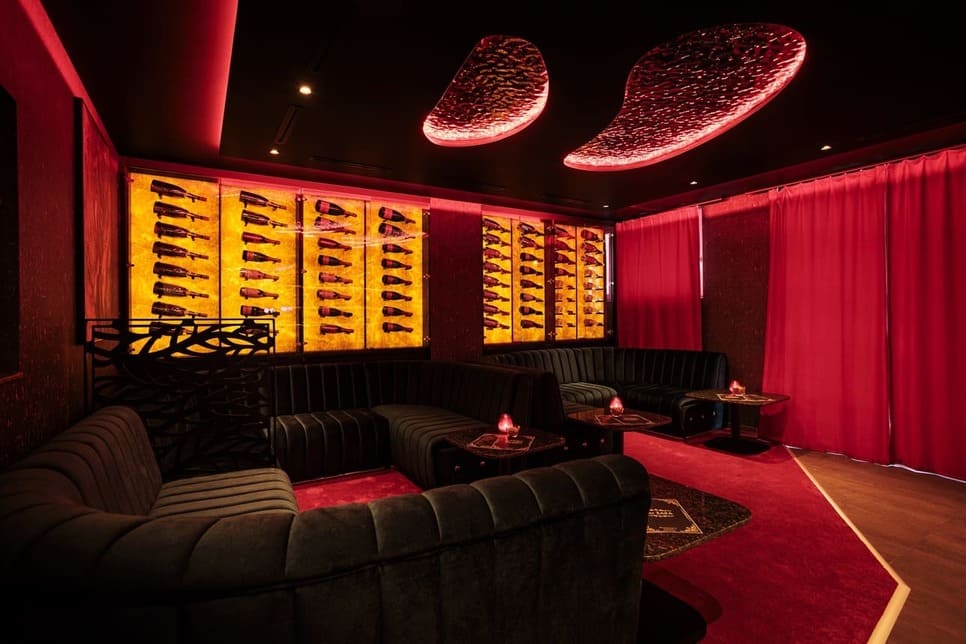 Loungebereich mit großen Sofas und einer Champagnerwand und rotem Teppich