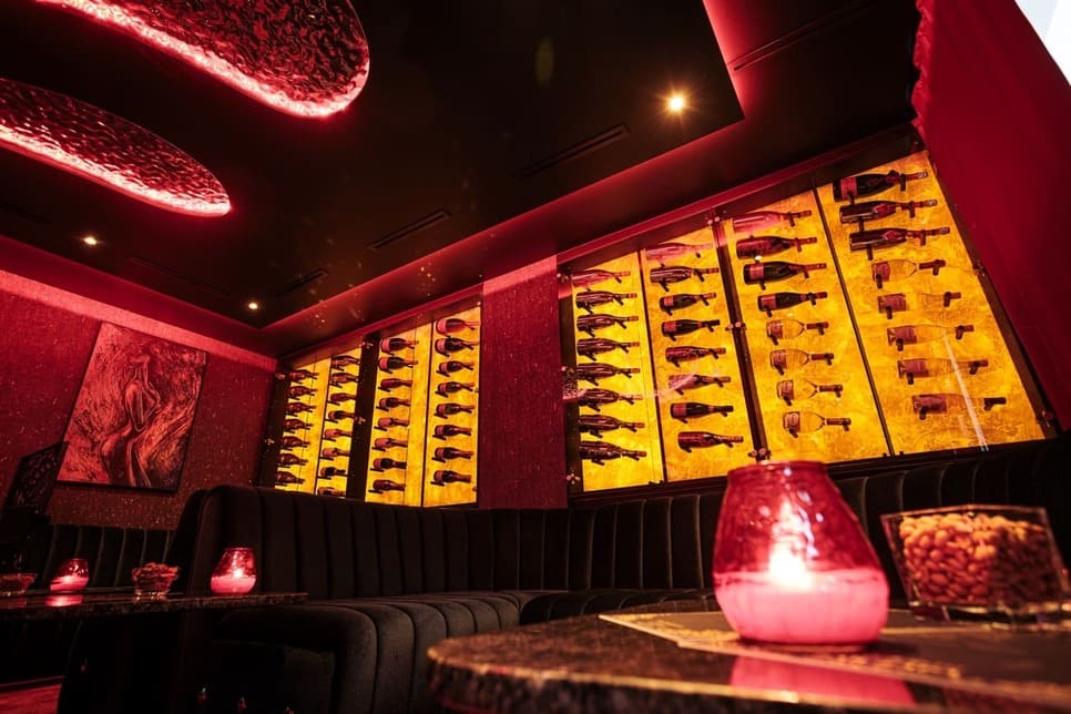 Loungebereich einer Bar mit einer Wand voller verschiedener Champagner Flaschen